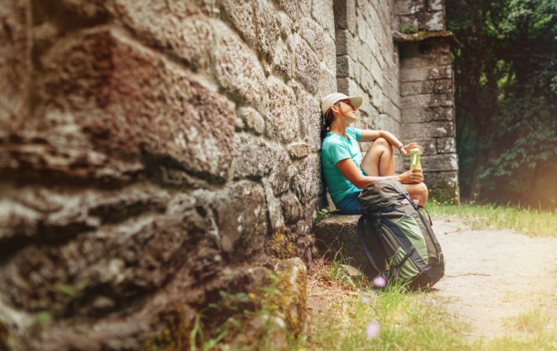 Tired,female,backpacker,resting,on,the,bench,near,the,old